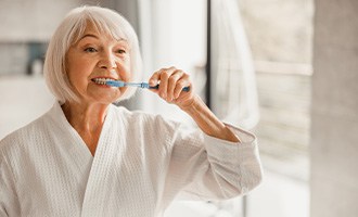 older woman brushing teeth