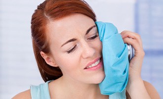 Woman with ice on her cheek