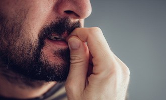 man biting fingernails