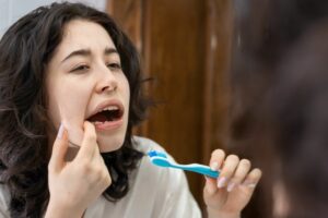 a person looking at their tooth in a mirror